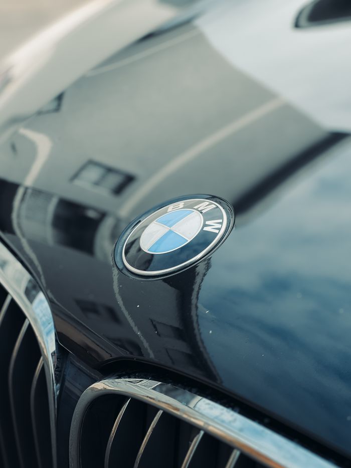 A detailed shot of a car emblem on a glossy vehicle hood, highlighting automotive design.